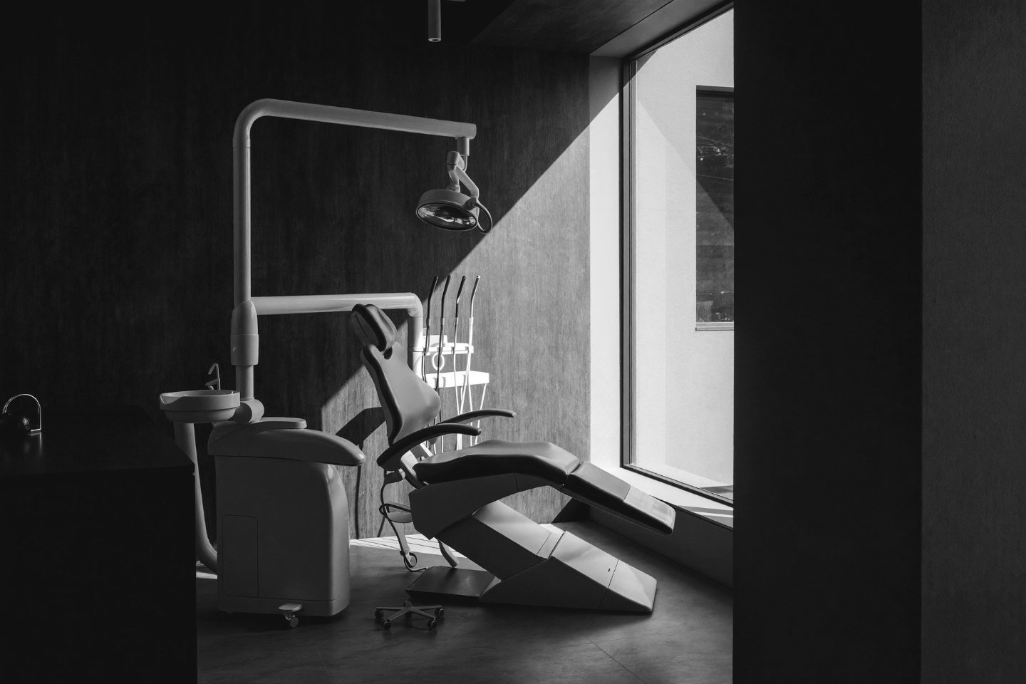 A modern dental surgery in soft window light — black and white photograph